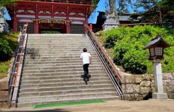 塩釜神社の階段を走って登る男