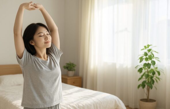 ベッドで背伸びをする女性