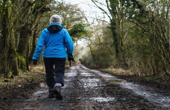 林道を歩く女性の後ろ姿
