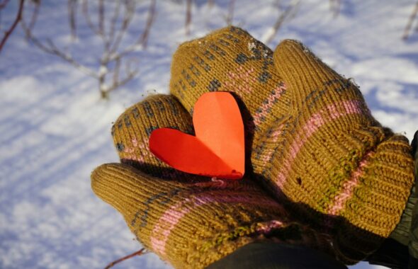 手袋の上に乗った、紙で出来たハート